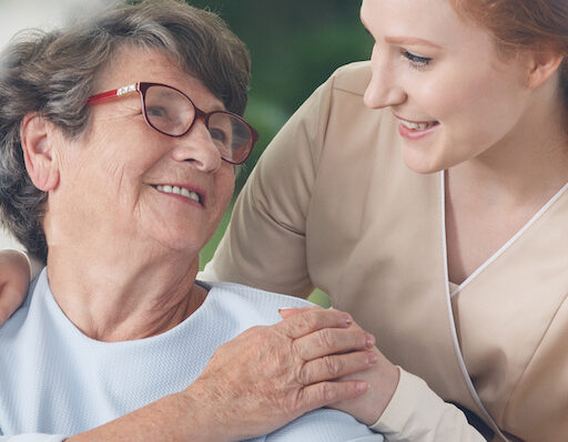 A close-up of a senior mother holding her young daughter's hand.