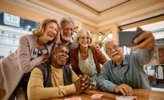 Cheerful senior have fun while taking selfie at retirement community of Senior Living apartments