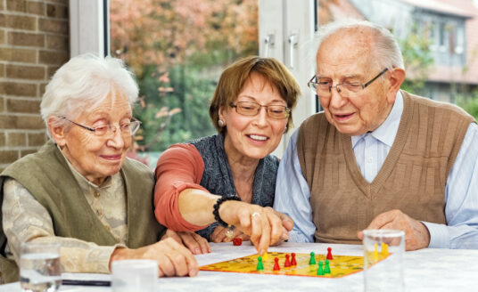 Elderly Couple and Daughter Playing Board Game