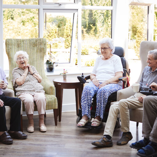 A group of seniors socialize at an independent living community, which offers safety and security to seniors living alone.