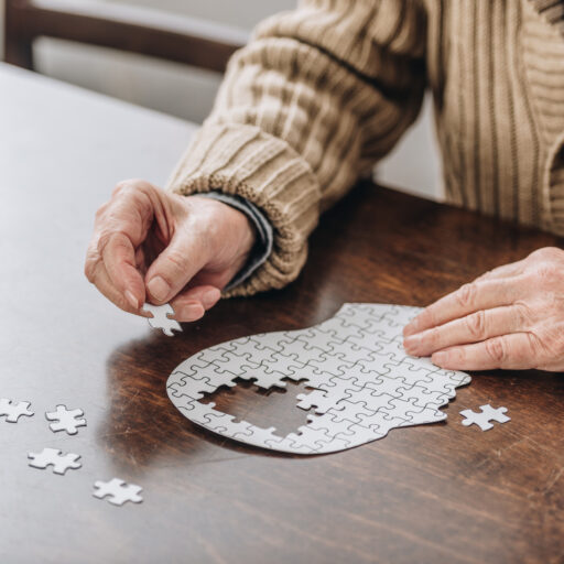 A senior man works on a puzzle, as he knows the importance of brain health