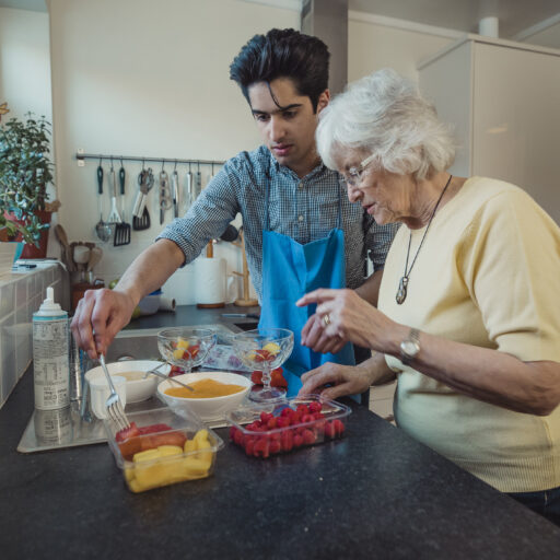 Young man preparing healthy meal with older adult for proper nutrition for seniors.
