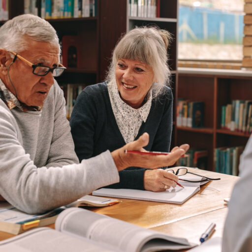 Seniors taking part in lifelong learning discussing topics in a library