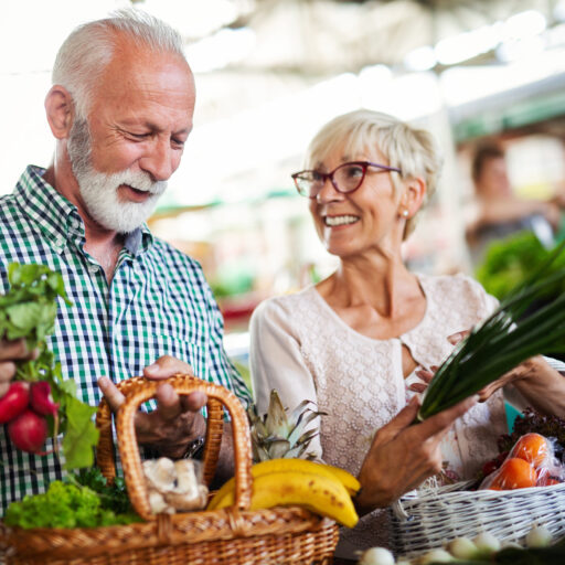 Senior couple picking out vegetables at local farmers market