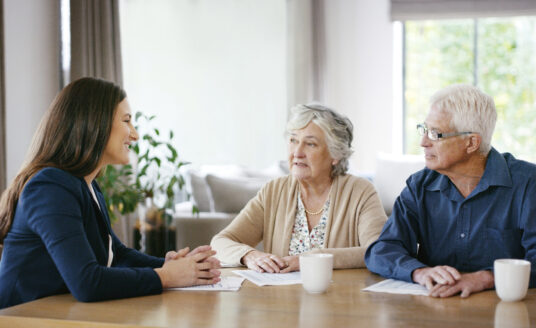 Advisor explaining health care documents to senior couple