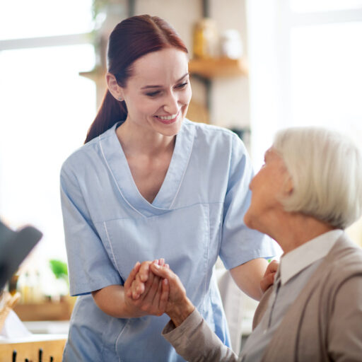 A nurse helps a senior woman at a memory care community
