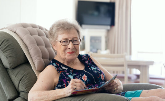 Older woman enjoying senior independence as she is seated in a comfortable recliner in her own home
