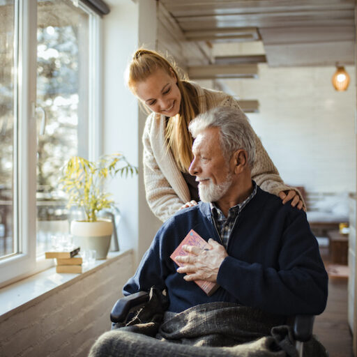A senior man talks to a nurse at his skilled nursing home community.