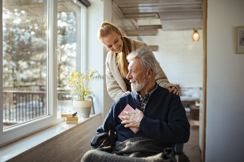 A senior man talks to a nurse at his skilled nursing home community.