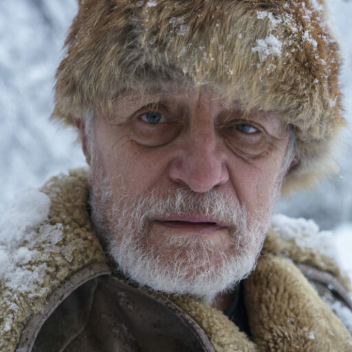 Confused older man looking at camera with fur hat and coat on while wandering with dementia.