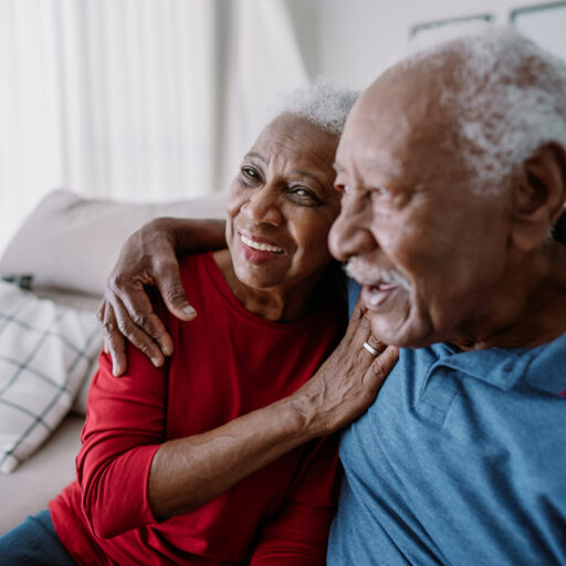 Senior couple hugging on couch | Assisted Living Options for Couples