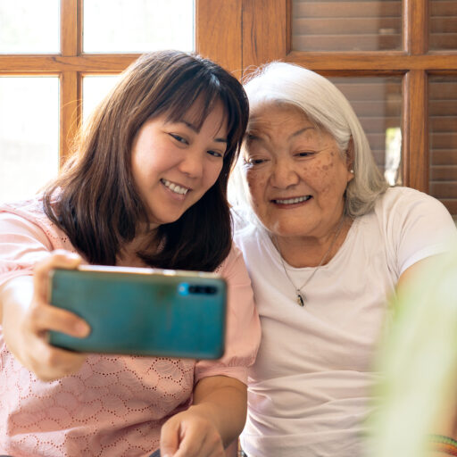 Granddaughter and senior grandmother staying connected through technology for seniors