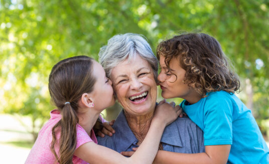 Celebrating Grandparents Day at Bethesda give seniors a chance to visit with their families. Here, a senior woman hugs her granddaughters.