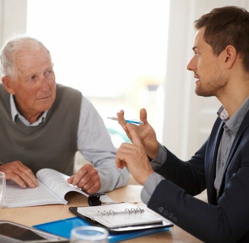 A senior Veteran talks with a Bethesda Hospice care worker, discussing Common VA Benefits and how to take advantage of them.