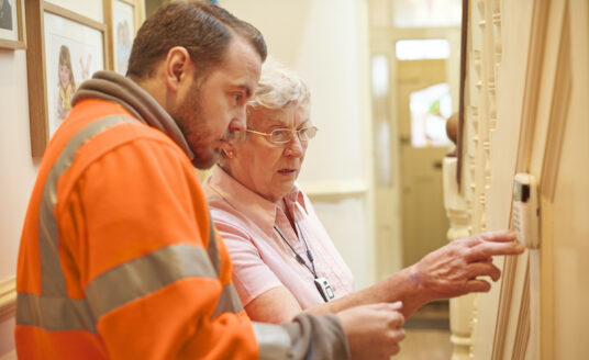 Senior checks home thermostat for safety
