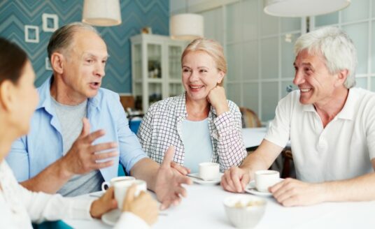 A group of seniors enjoy a meal at their retirement community, just one of the independent living amenities offered.
