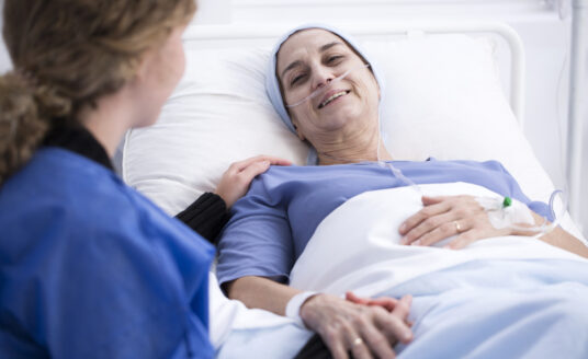 A woman talks to her loved one in hospice care.