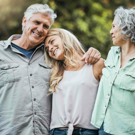 Loving family embracing senior parents, overcoming fear of change by considering the benefits of senior living communities.
