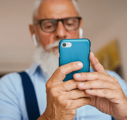 A senior man looks at hearing aid apps on his smart phone.